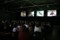 Die Bildschirme im Hangar 1 zeigen die vier Musiker in Nahaufnahme